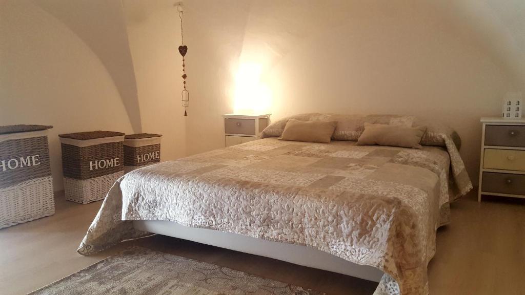 een slaapkamer met een bed, 2 dressoires en een lamp bij Maison de Famille in Acerenza