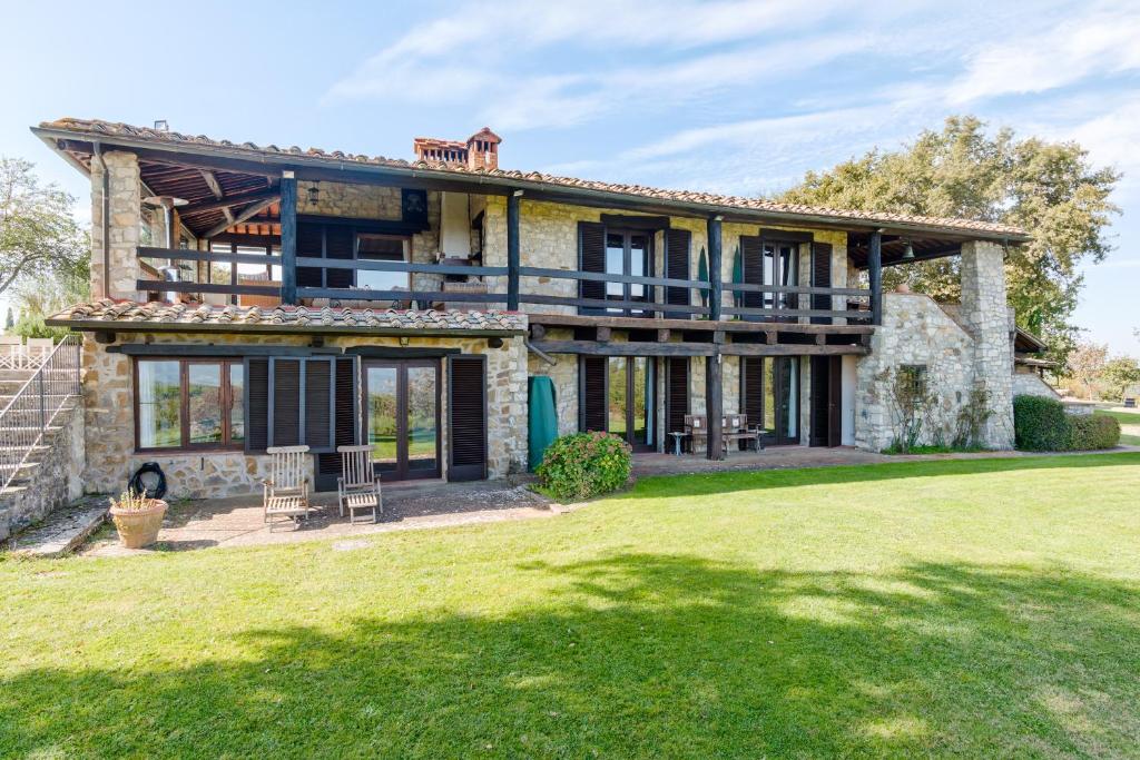 une grande maison en pierre avec une grande cour dans l'établissement Casale Cipressi, à Castellina in Chianti