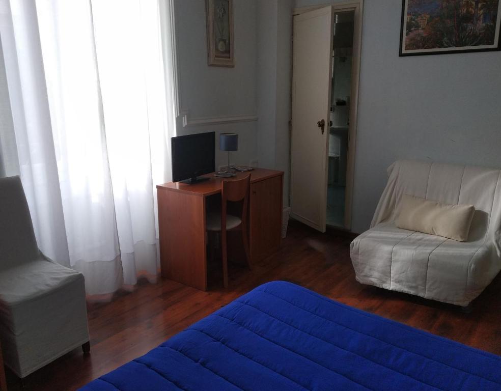 sala de estar con sofá y escritorio con TV en Hotel Lucciola en Bordighera