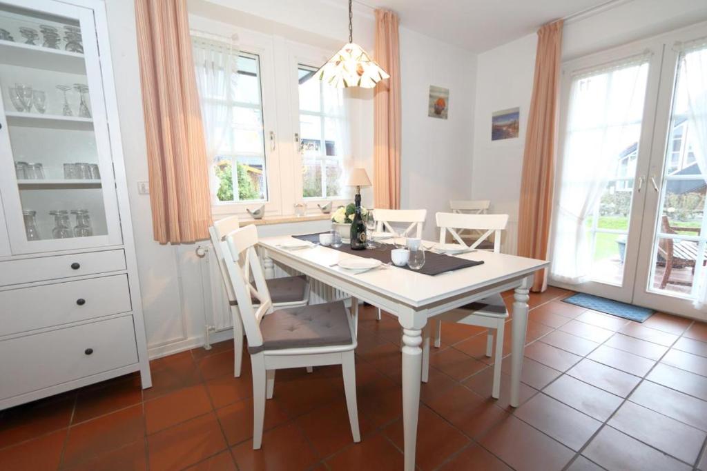comedor con mesa blanca y sillas en Südstrand 11 en Westerland
