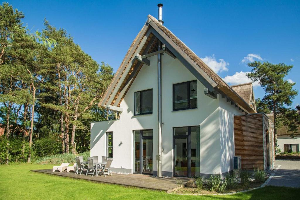 uma casa branca com um telhado de gambrel em Lotsenstieg 13a em Ostseebad Karlshagen