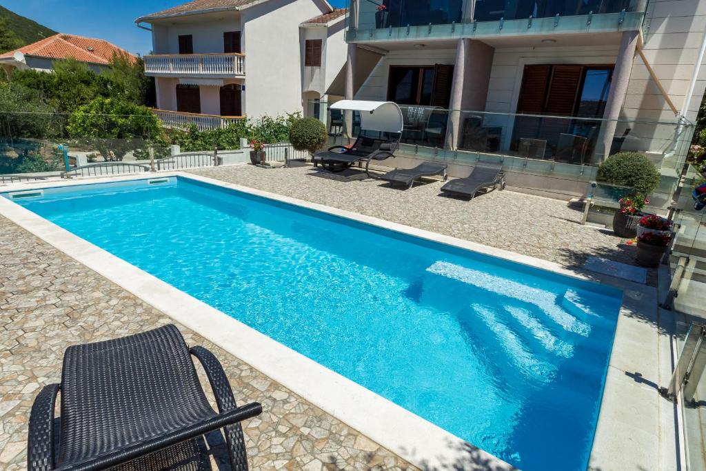a swimming pool in front of a house at Vila Orada in Molat