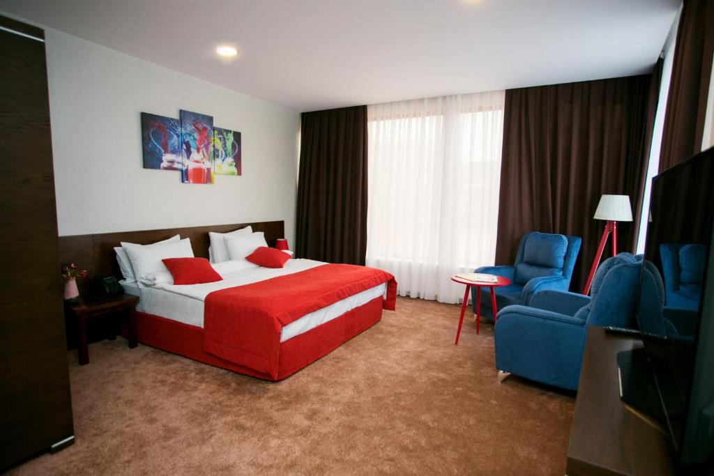 um quarto de hotel com uma cama e uma cadeira azul em Da Vinci Hotel em Baku