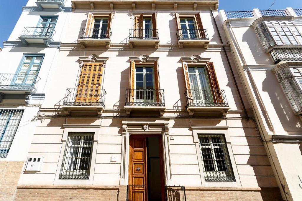 a white building with windows and a door at Teatro Suites Málaga in Málaga