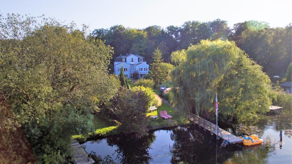 默爾恩的住宿－Pension Seeschlösschen，享有房子和树木繁茂的湖泊的空中景致