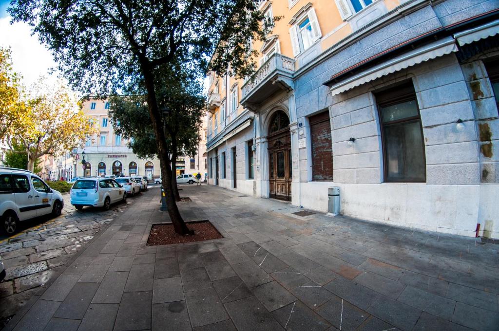 a tree on a sidewalk next to a building at Agli incanti in Trieste