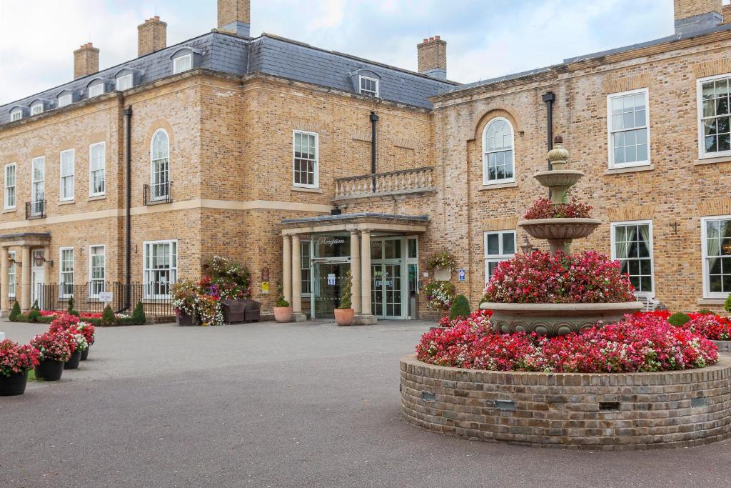 a large brick building with a fountain in front of it at Orsett Hall in Orsett