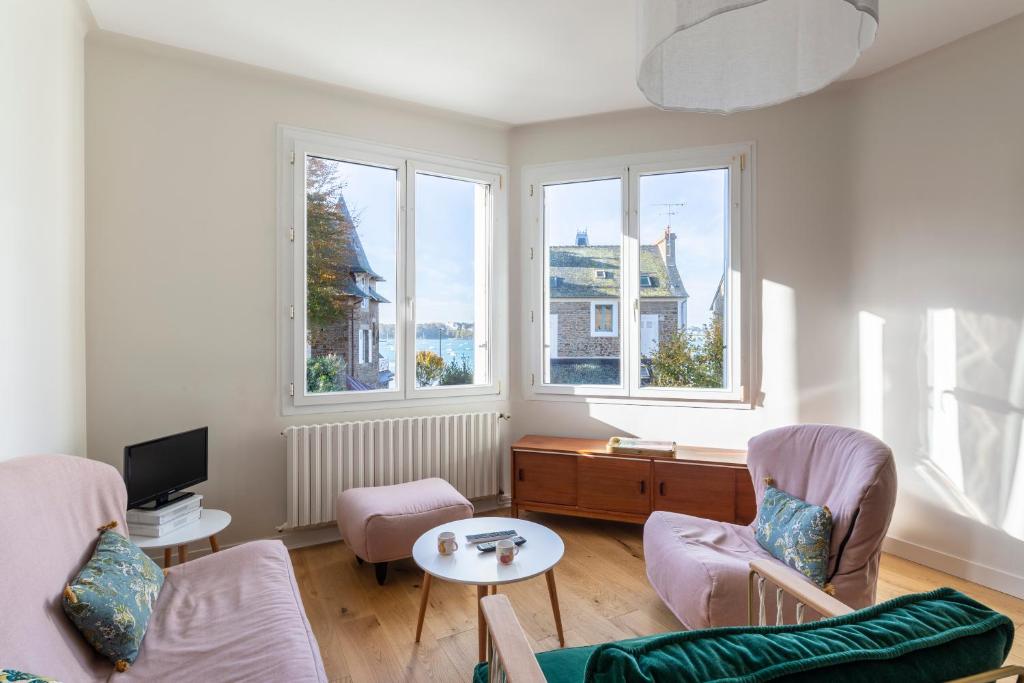 - un salon avec deux chaises, une table et deux fenêtres dans l'établissement LE TIMONIER by Cocoonr, à Saint-Malo