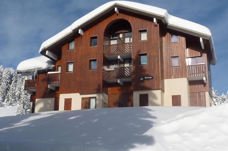 un bâtiment avec de la neige devant lui dans l'établissement LE Refuge 4005, à Manigod