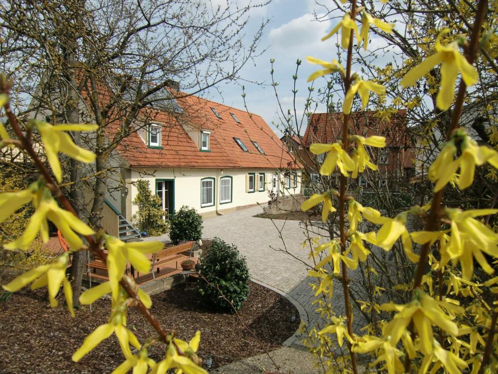 una casa con flores amarillas frente a un banco en Arnold´s Ferienhof, en Stadtlauringen