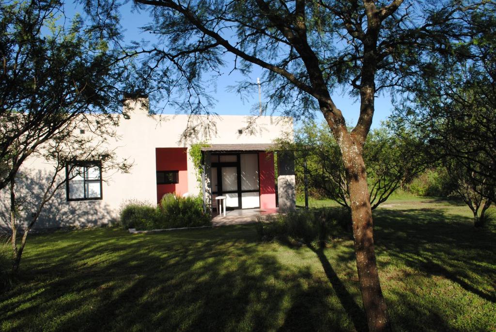 a white house with a tree in the yard at Casas del Champaquí in San Javier