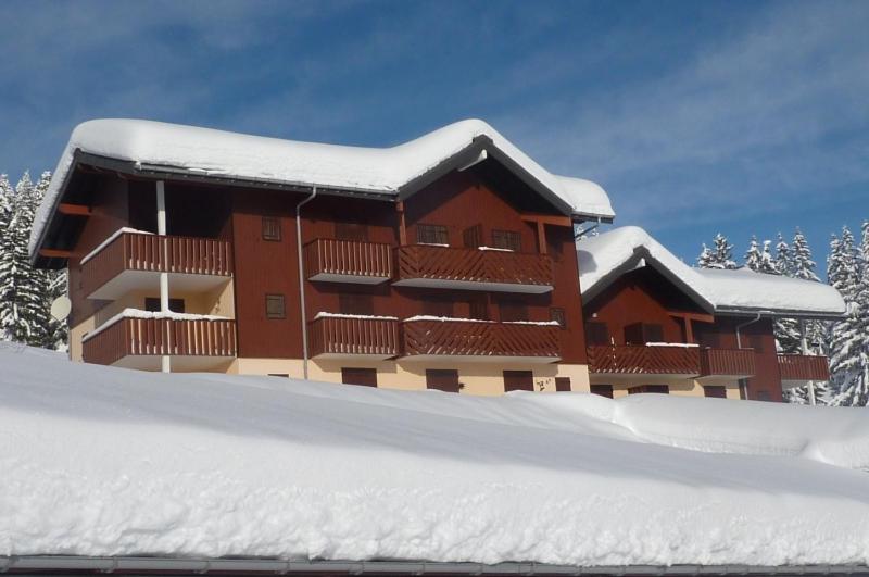 un bâtiment recouvert de neige avec un tas de neige dans l'établissement MONT BLANC SOLEIL E-2, à Manigod