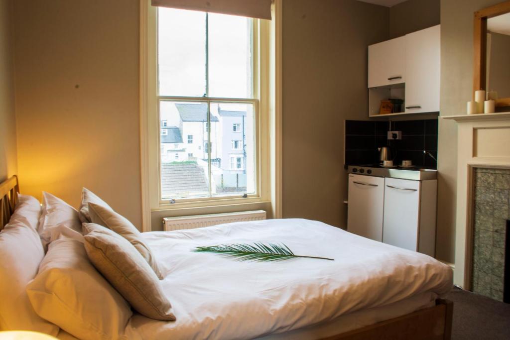 a bedroom with a large white bed with a window at Amherst Brighton in Brighton & Hove