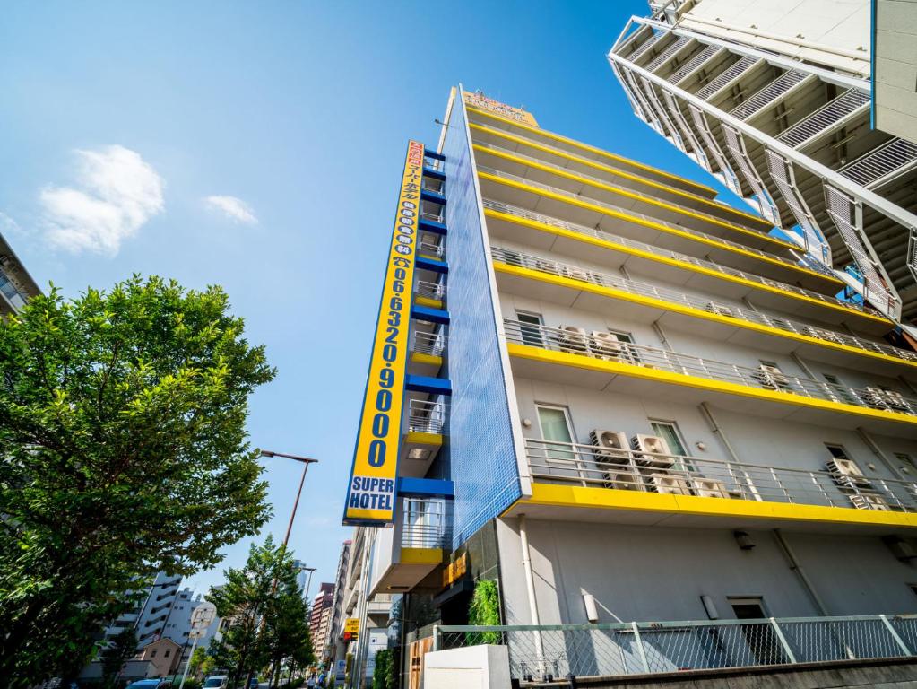 大阪的住宿－新大阪東口超級酒店，建筑的侧面有黄色标志