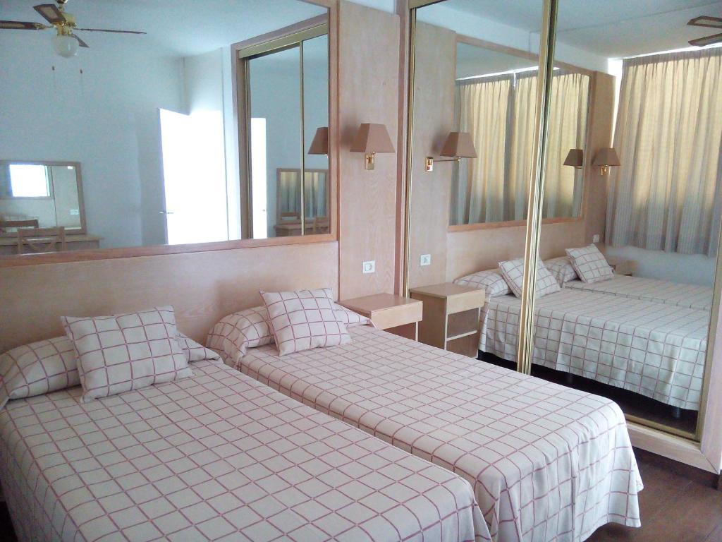 ロス・クリスティアーノスにあるAzahara Beach 416のベッドルーム1室(ベッド2台、鏡付)