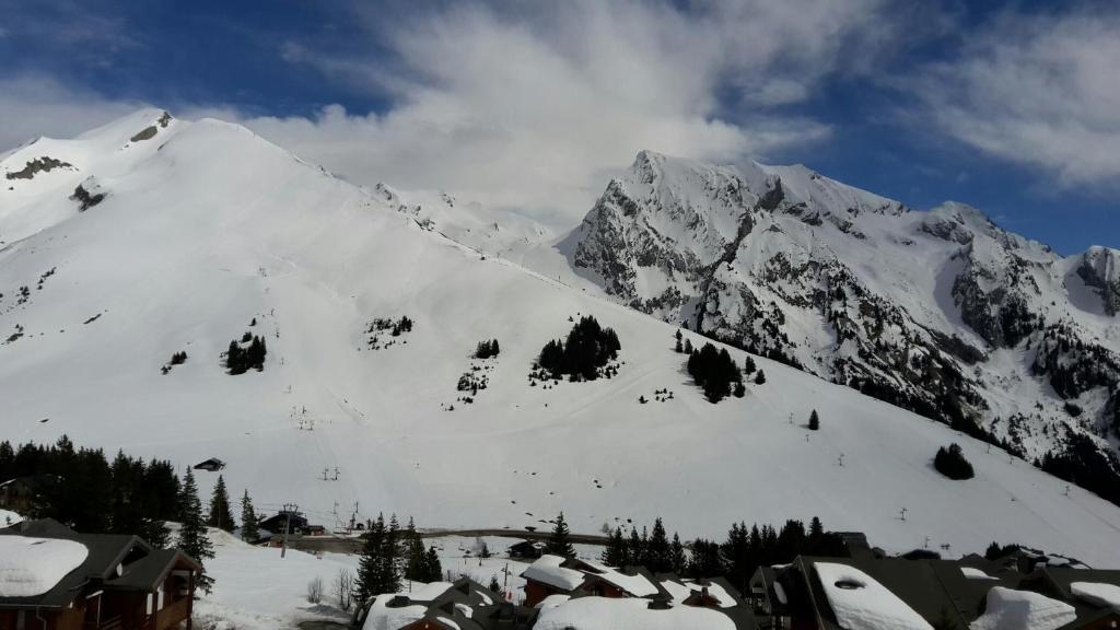a snow covered mountain with a small town in front at MONT BLANC Soleil C-4 in Manigod