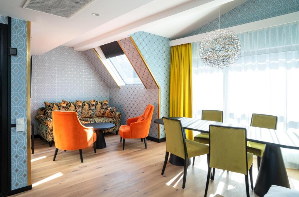 ein Esszimmer mit orangefarbenen Stühlen und einem Tisch in der Unterkunft Thon Hotel Cecil in Oslo