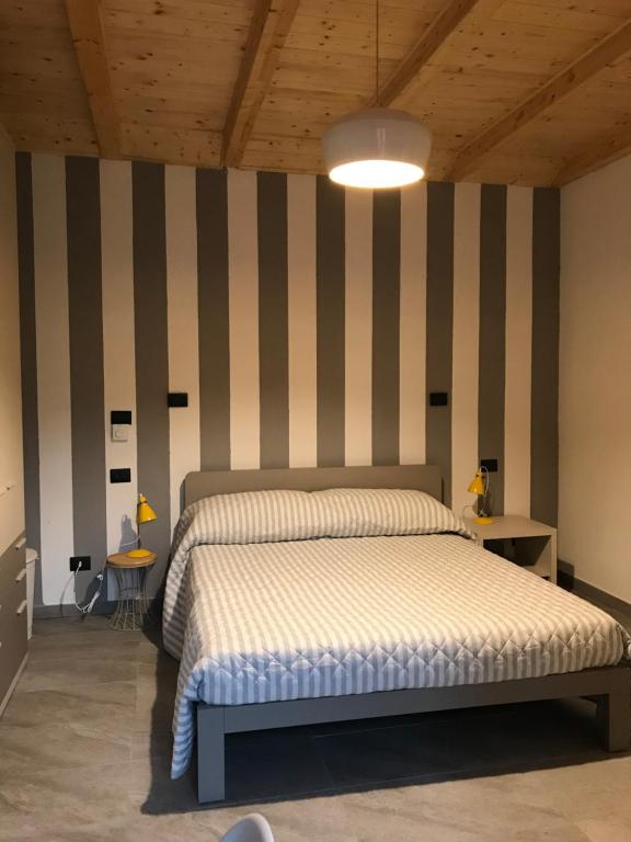 1 dormitorio con cama y pared a rayas en Il fienile b&b, en Stazzano