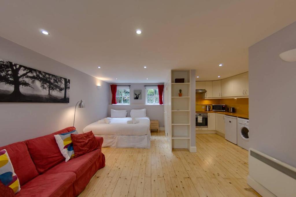 - un salon avec un lit et un canapé rouge dans l'établissement ALTIDO Warm and Welcoming flat near Edinburgh Castle, à Édimbourg