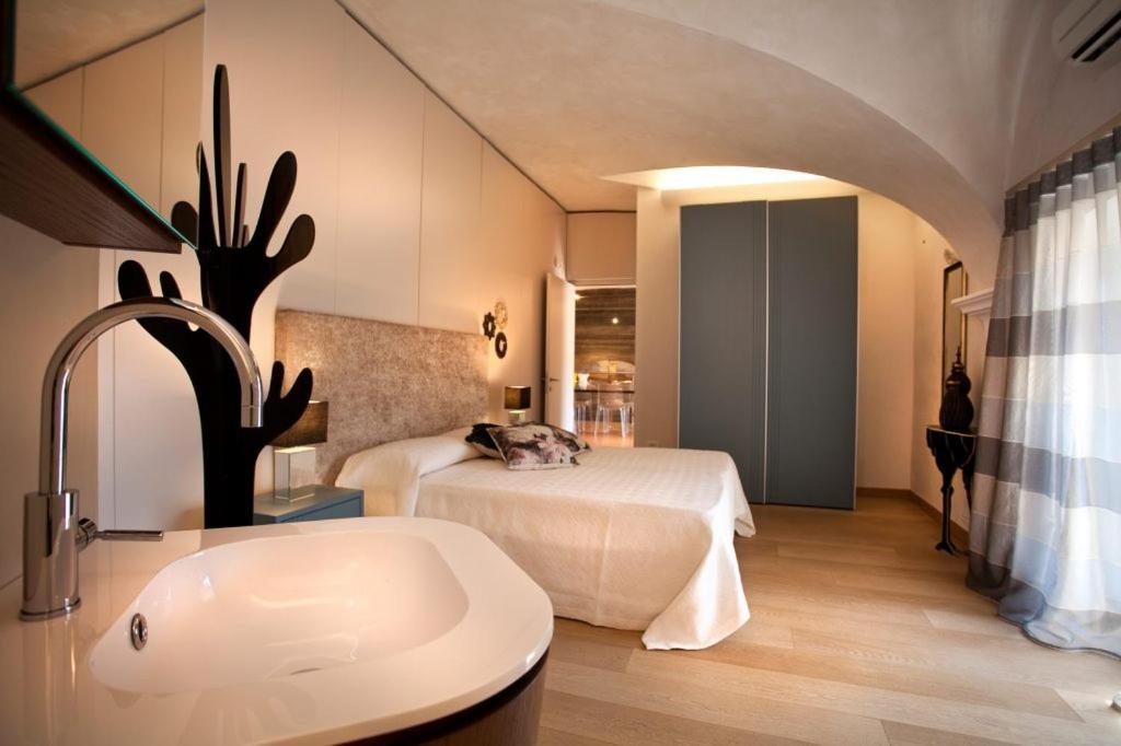a bedroom with a bed and a bathroom with a sink at Anfite Luxury Apartment Affresco San Silvestro in Verona
