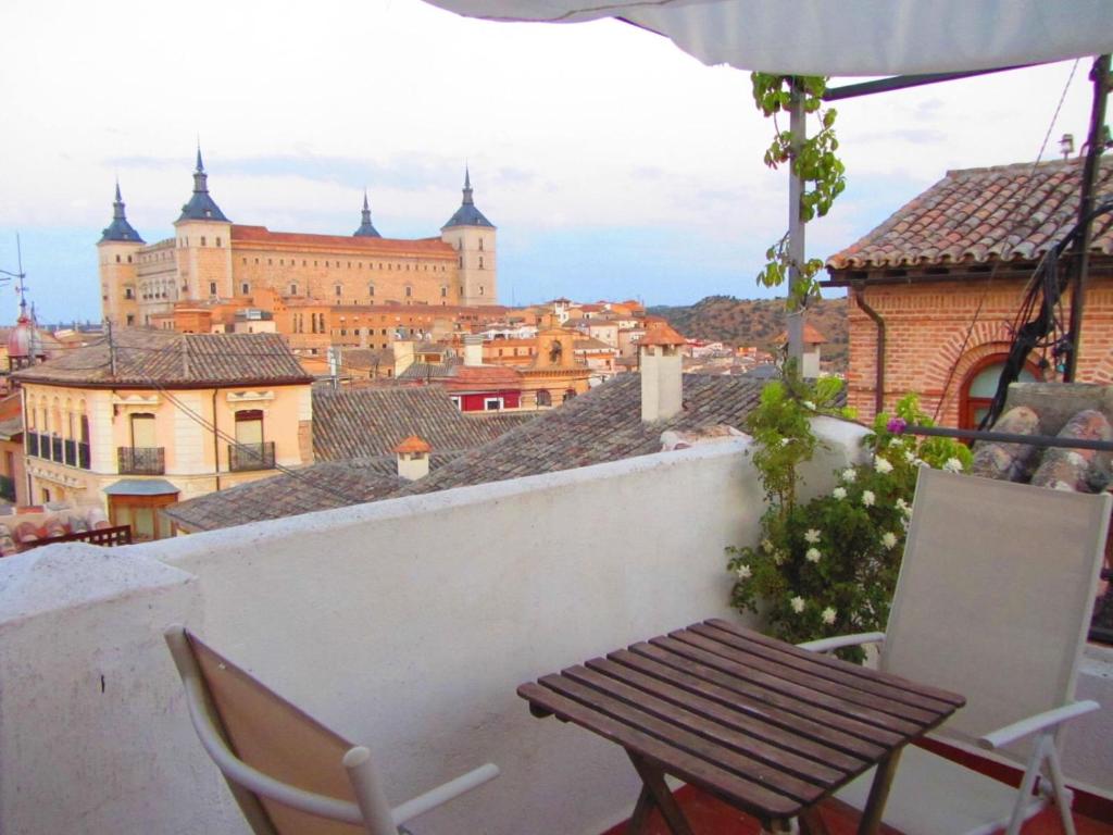 a table and chairs on a balcony with a view of a city at La Plata in Toledo