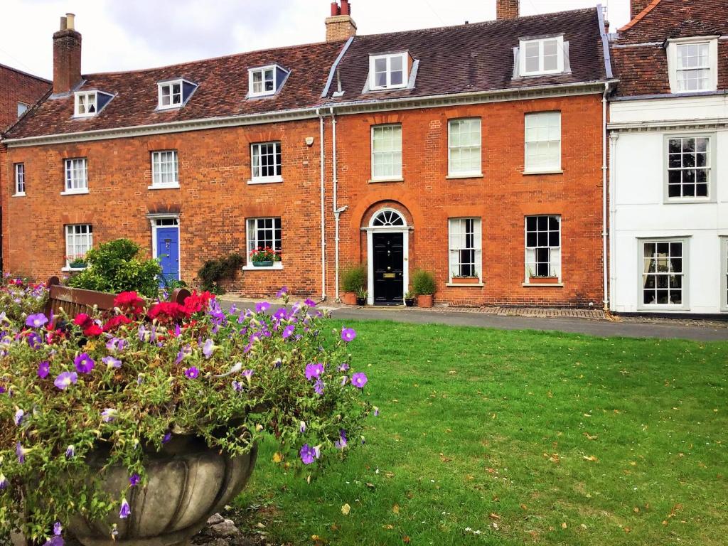 a large red brick building with flowers in the yard at St Mary’s Bed & Breakfast in Bury Saint Edmunds