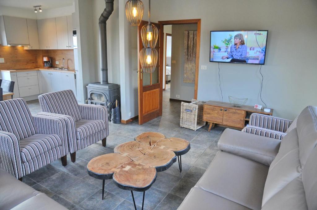 a living room with a couch and tables and a stove at Vue de Rome in Durbuy