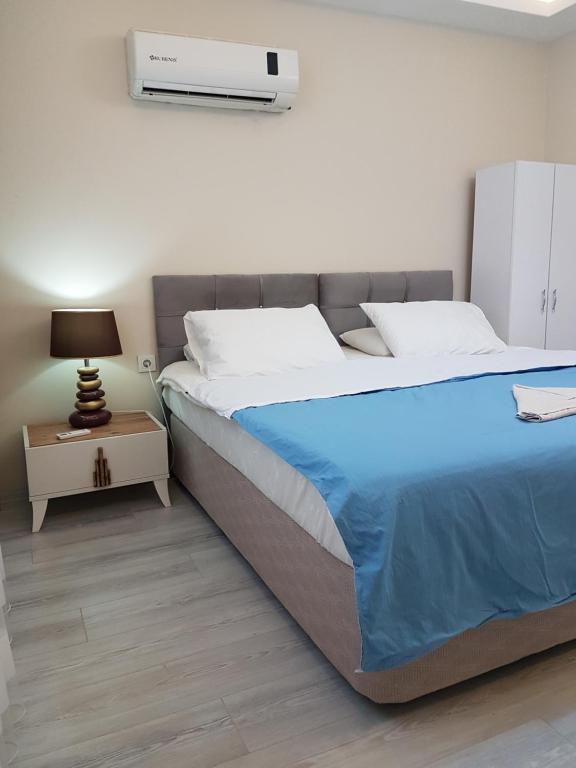 a bedroom with a large bed and a night stand at Yeşilyurt Residence in Izmir