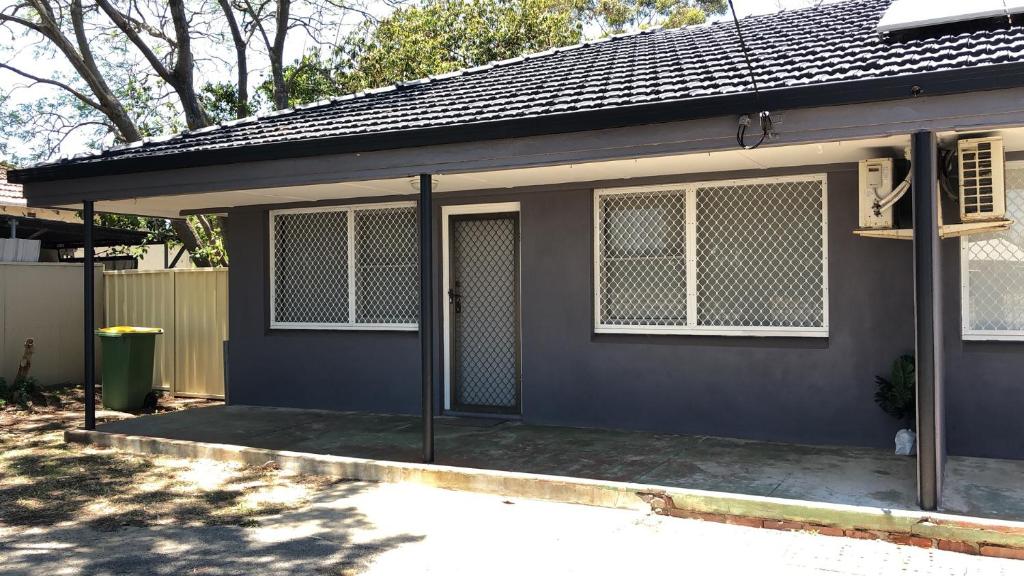 una pequeña casa con una valla delante de ella en Maddington House Unit C en Perth