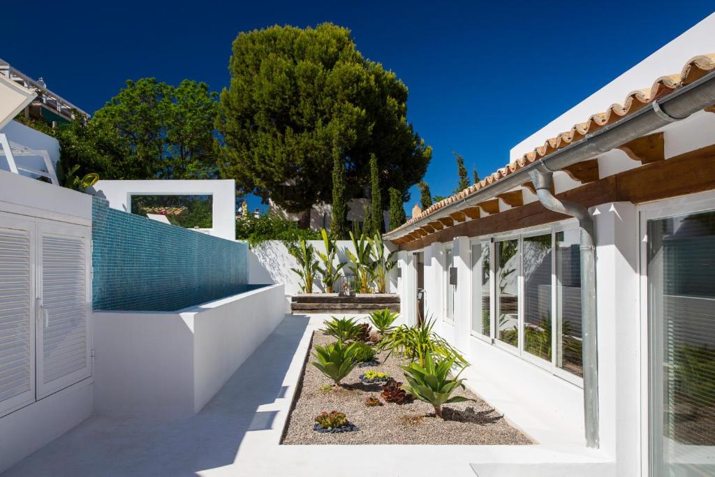 a white house with a blue roof at Villa Oasis by PriorityVillas in Palma de Mallorca