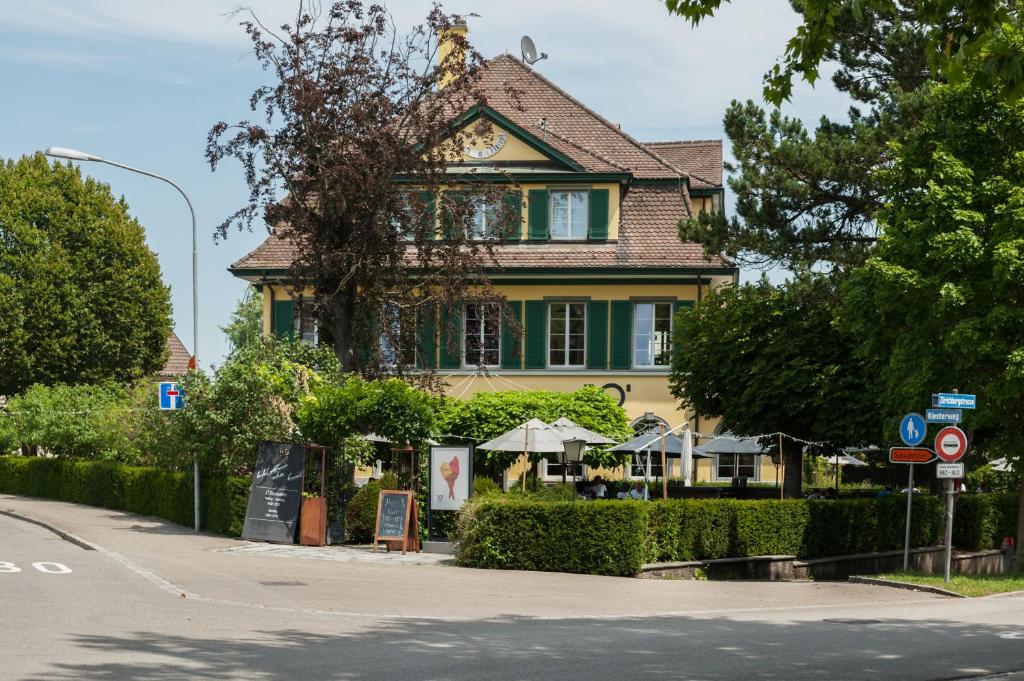 una gran casa amarilla con una zona verde en Guest House Dieci allo Zoo, en Zúrich