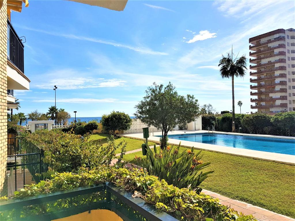 uitzicht op een tuin met een zwembad bij Fuengirola playa beachfront in Fuengirola