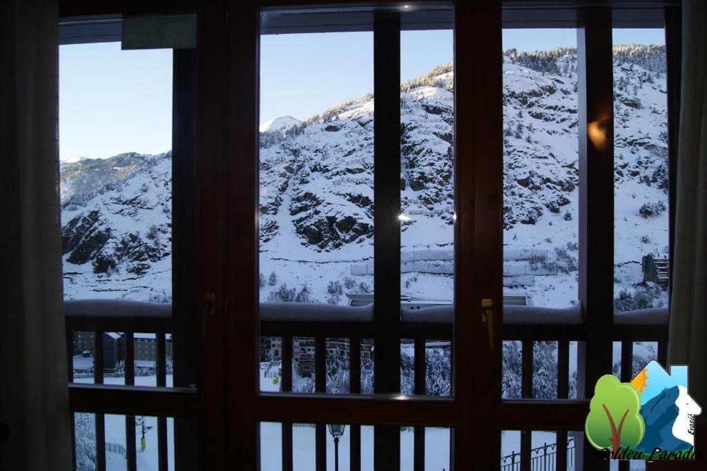 a view of a snow covered mountain through a window at Soldeu Paradis Pleta in Soldeu