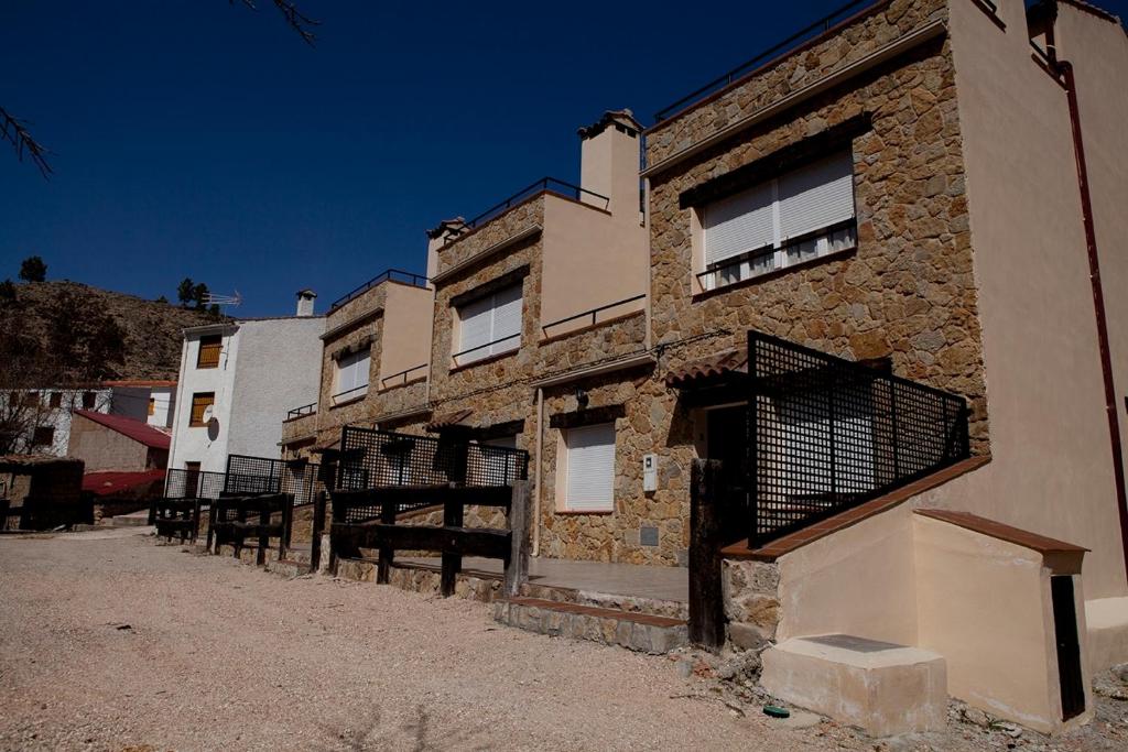 ein altes Backsteingebäude mit einem Tor davor in der Unterkunft Apartamentos Río Madera in Segura de la Sierra