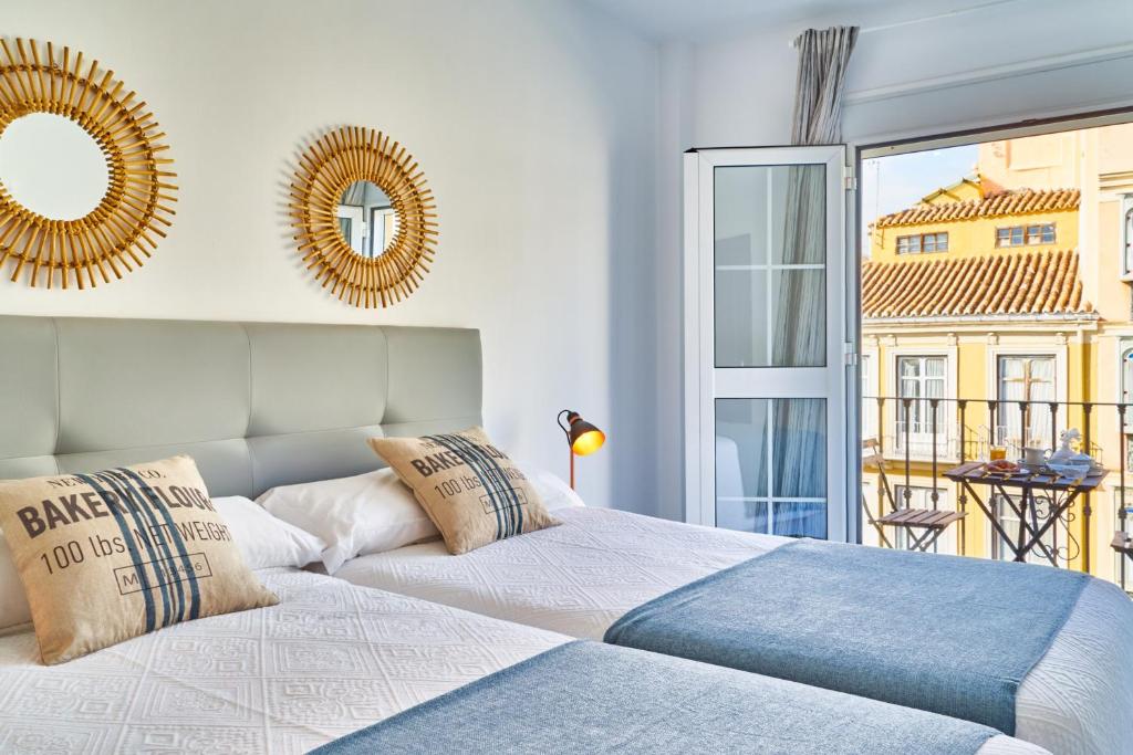 a bedroom with two beds and a large window at iloftmalaga Puerta del Mar in Málaga