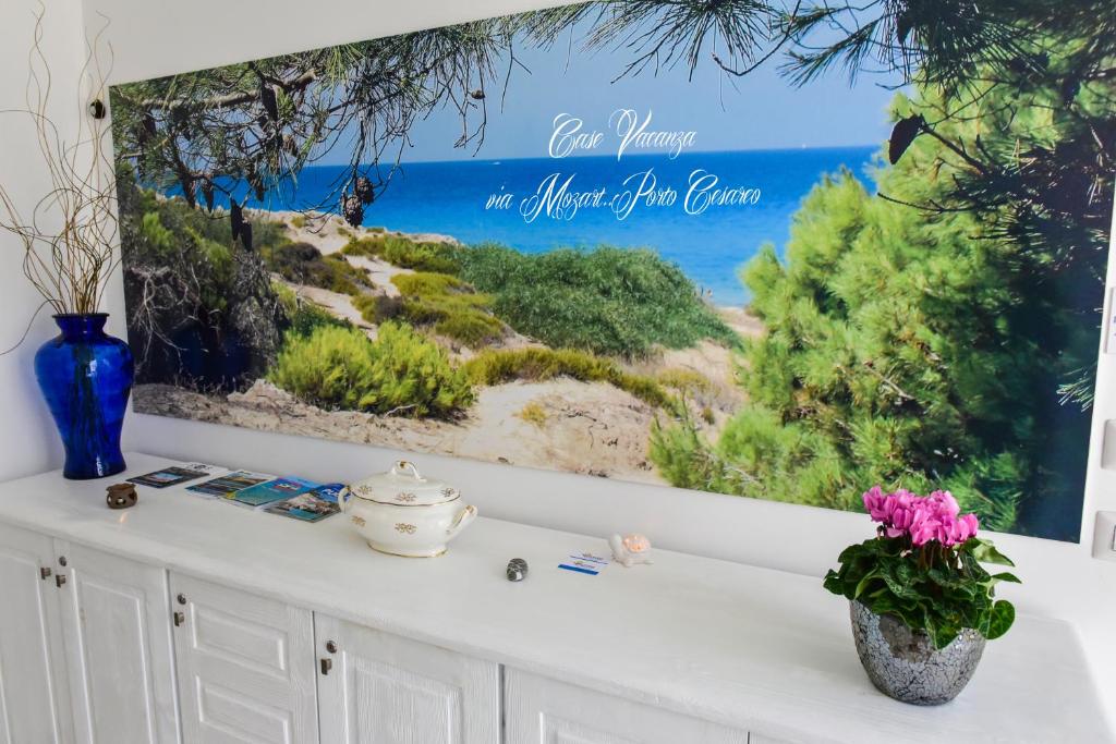 a picture hanging on a wall with a picture of the beach at Case Vacanza Via Mozart in Porto Cesareo