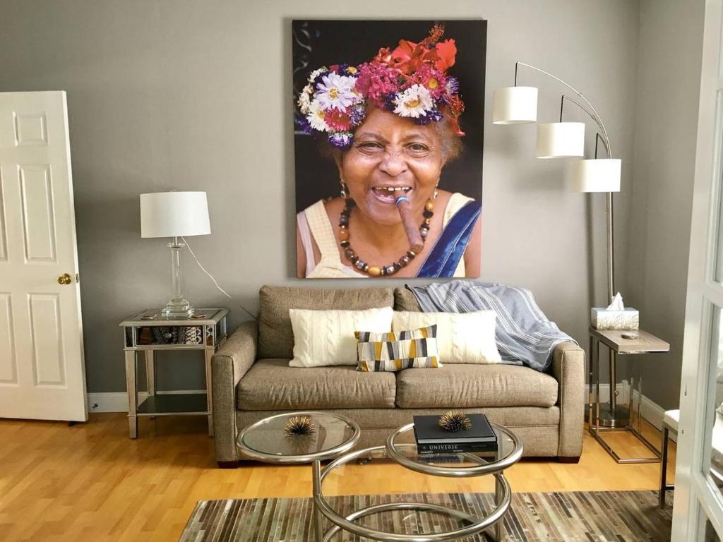 a living room with a painting of an older woman at ~*30min to Downtown*~ THE COSMOPOLITAN in Boston