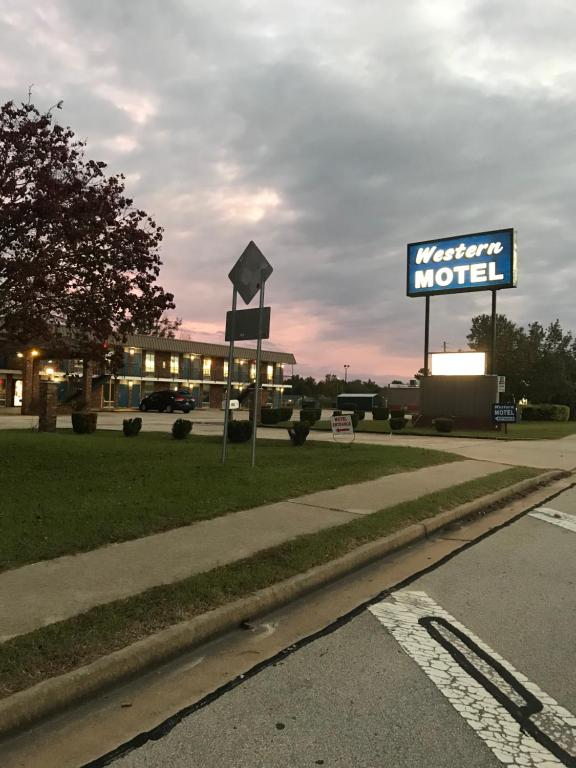 una señal para un motel frente a un edificio en WESTERN MOTEL, en Brinson Crossing