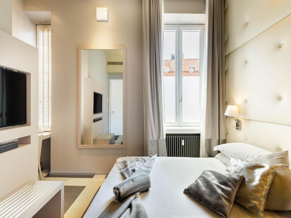 ローマにあるPrivate Luxury Suitesのベッドと鏡が備わるホテルルーム