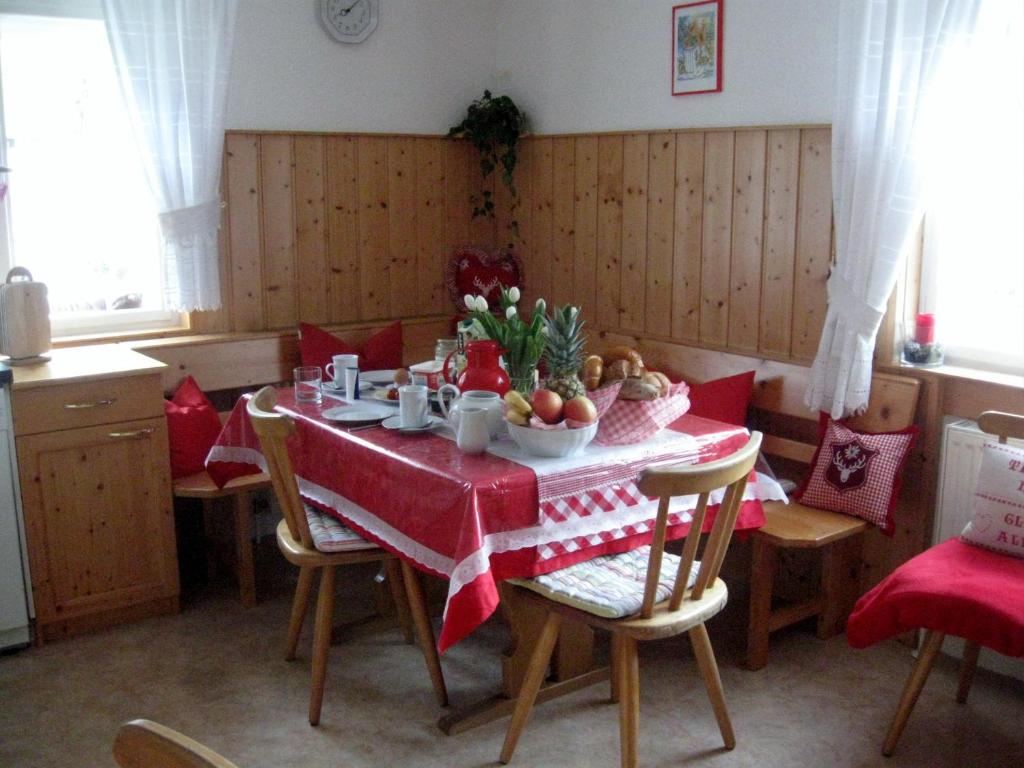 a dining room with a table with a red table cloth at Haus Klinger in Gaschurn