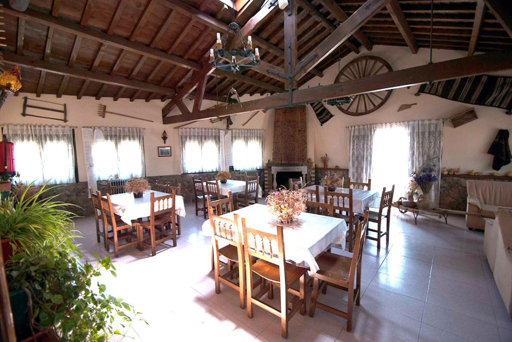 a dining room with tables and chairs and windows at Los Arribes in Moralina
