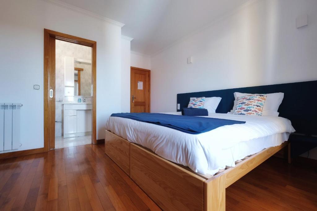 sypialnia z dużym łóżkiem z drewnianą ramą w obiekcie InnEsposende Sports Hostel w mieście Esposende