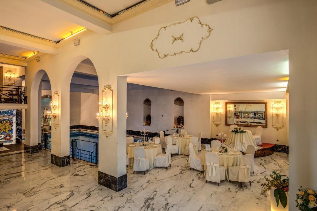 salę bankietową z białymi stołami i białymi krzesłami w obiekcie Hotel Castel Vecchio w mieście Castel Gandolfo