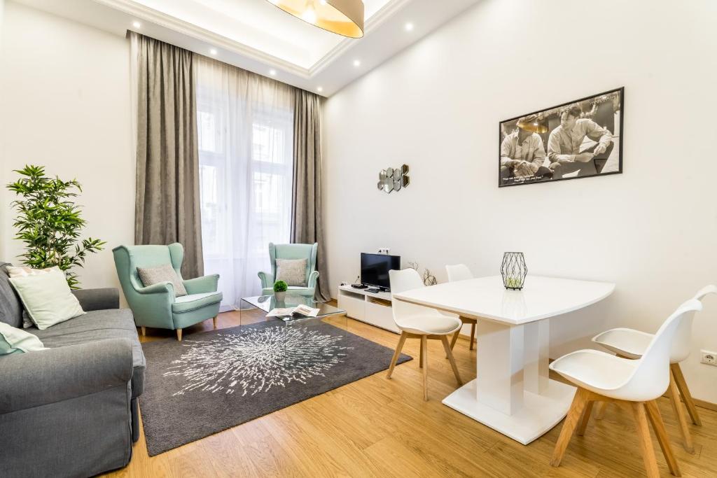 a living room with a couch and a table and chairs at Hello Downtown Apartment - Movie in Budapest