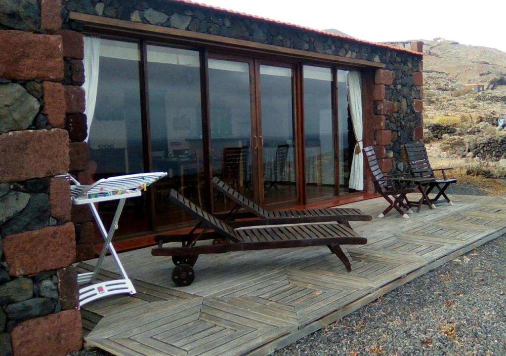 a deck with two chairs and a grill on a house at casa La Perdiz in Valverde