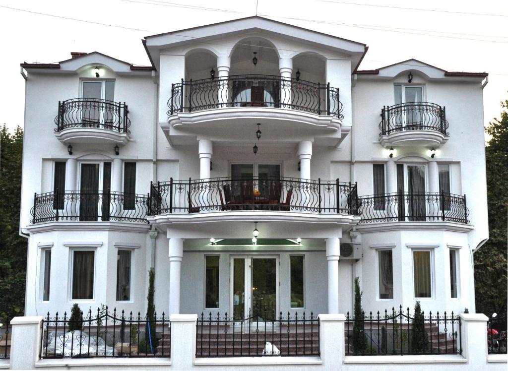 a white house with balconies on top of it at Villa Bella Boutique Hotel in Kavadarci