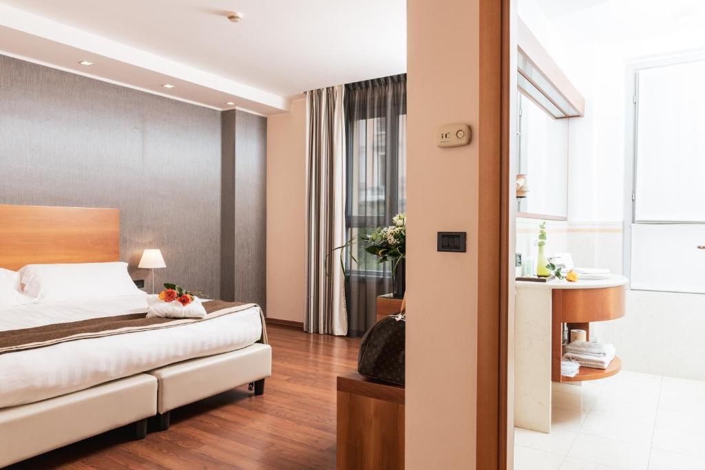 ein Hotelzimmer mit einem Bett und einem Bad in der Unterkunft Hotel Royal Falcone in Monza