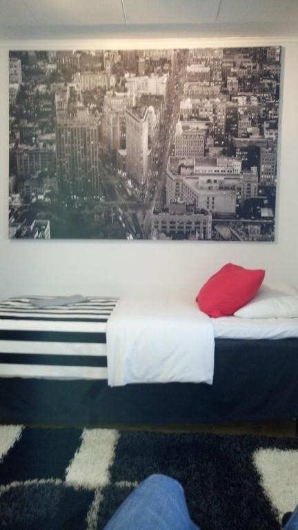 Ce lit se trouve dans un dortoir avec une photo de la ville. dans l'établissement M Apartments Tuularinkatu, à Tampere