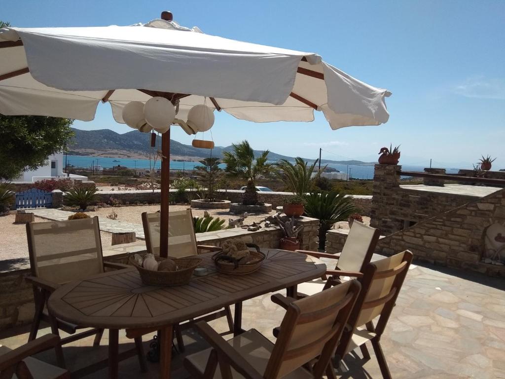 Agios GeorgiosにあるDespotiko Viewのパティオ(パラソル付きのテーブルと椅子付)