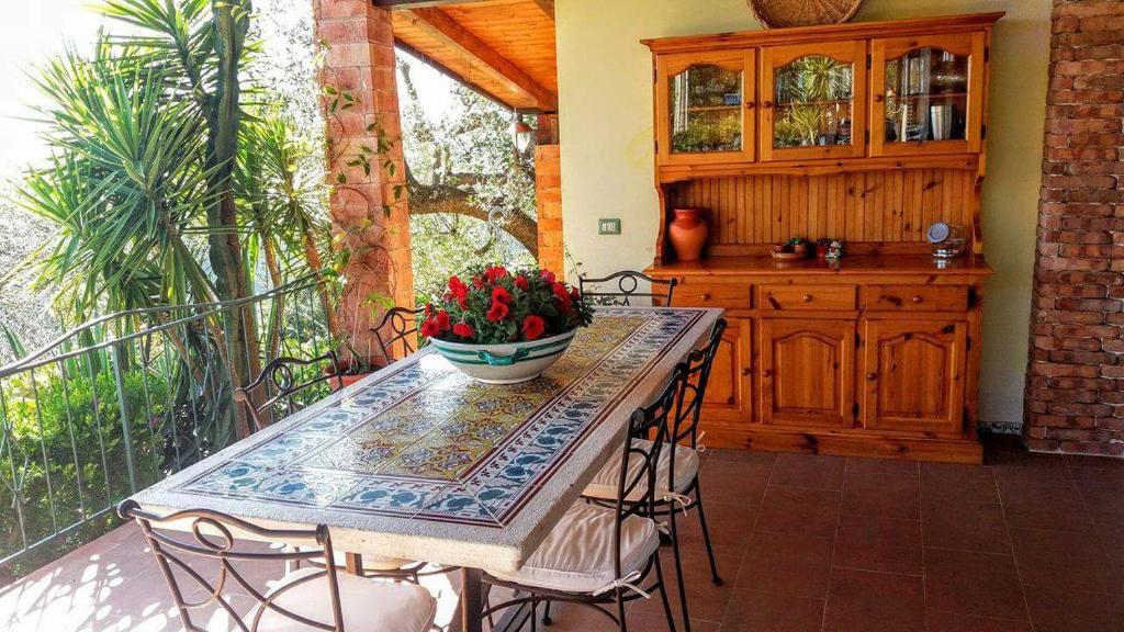 a table and chairs on a balcony with a kitchen at B&B Le Anthos in Marina di Camerota